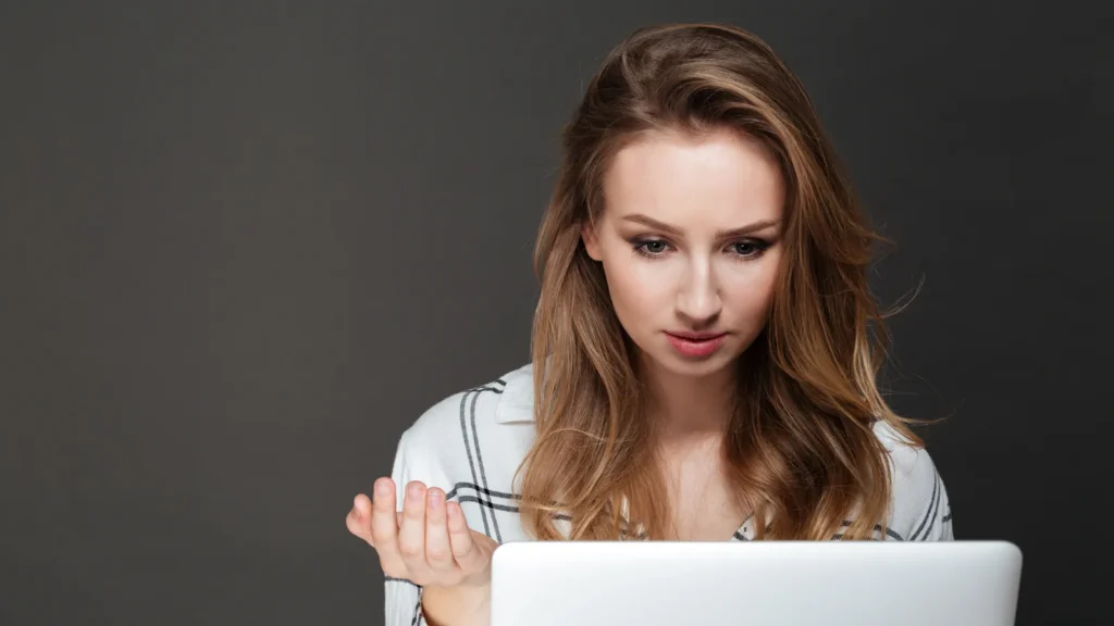 Ragazza perplessa davanti allo schermo del portatile